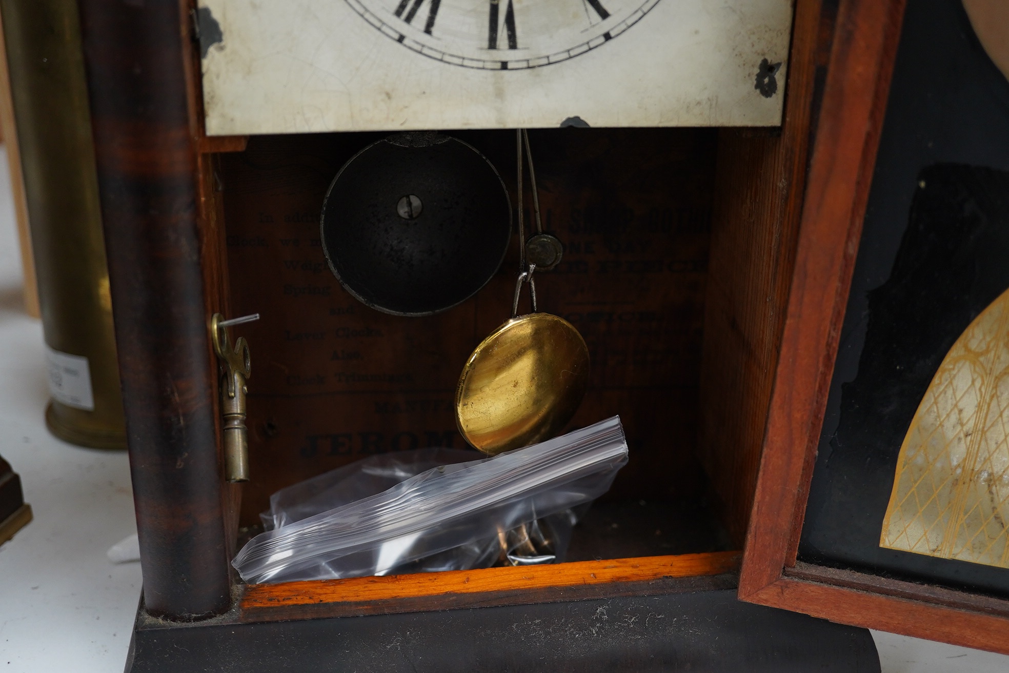 Two clocks including an American example, with keys and two military interest brass shells. Condition - fair